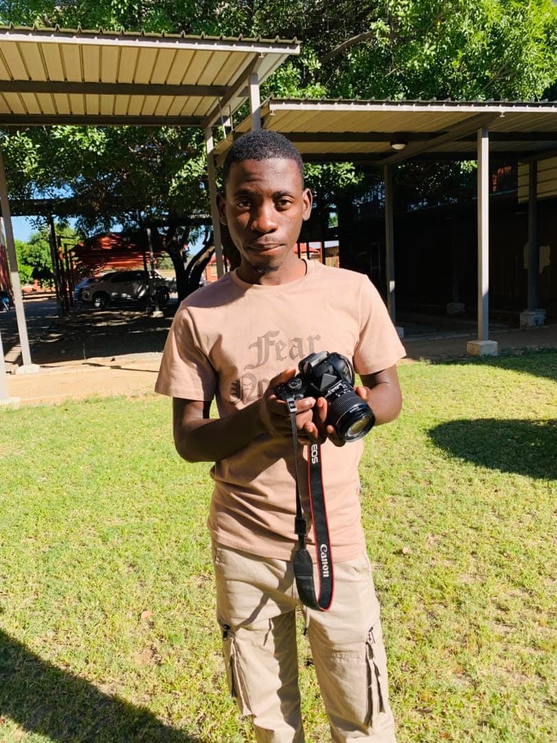 Kudumo Kupembona Andreas holding a camera outdoors