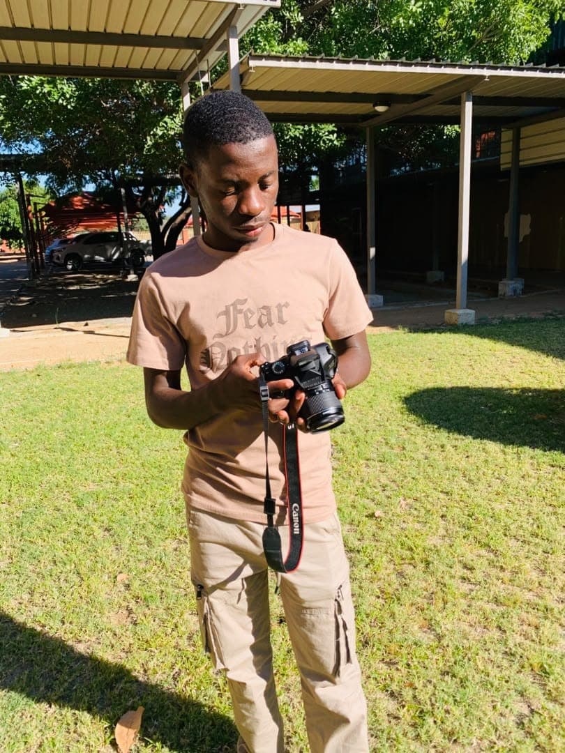Kudumo Kupembona Andreas working with a camera outdoors